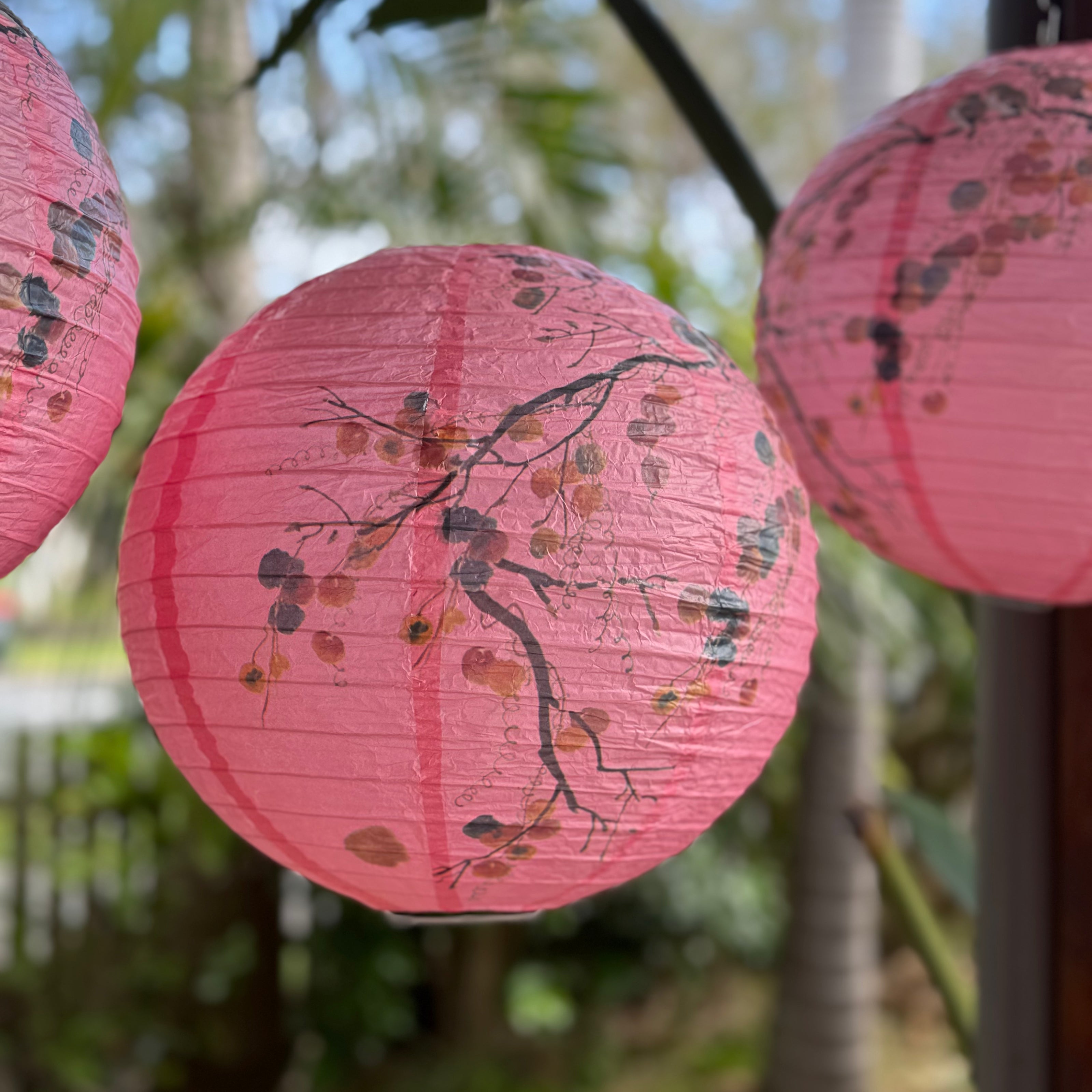Pink printed lanterns hanging from trees