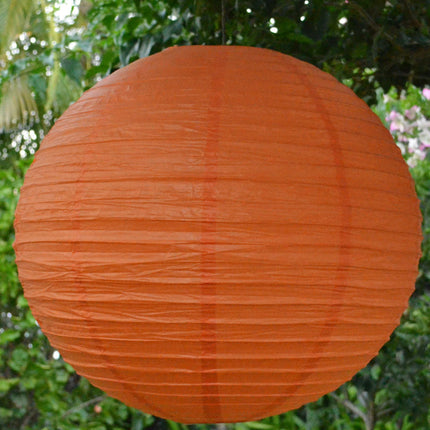 large orange paper lantern hanging in trees